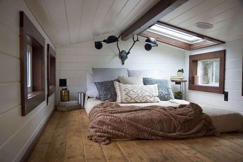 A bedroom lit by a large skylight