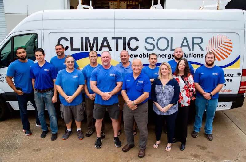 A photo of a team of Climatic solar workers in front of a company work van