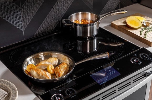 ge induction stove with food cooking in pans on burners