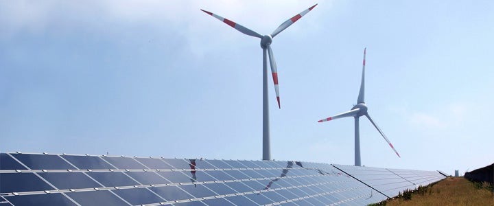 wind turbines behind solar panels