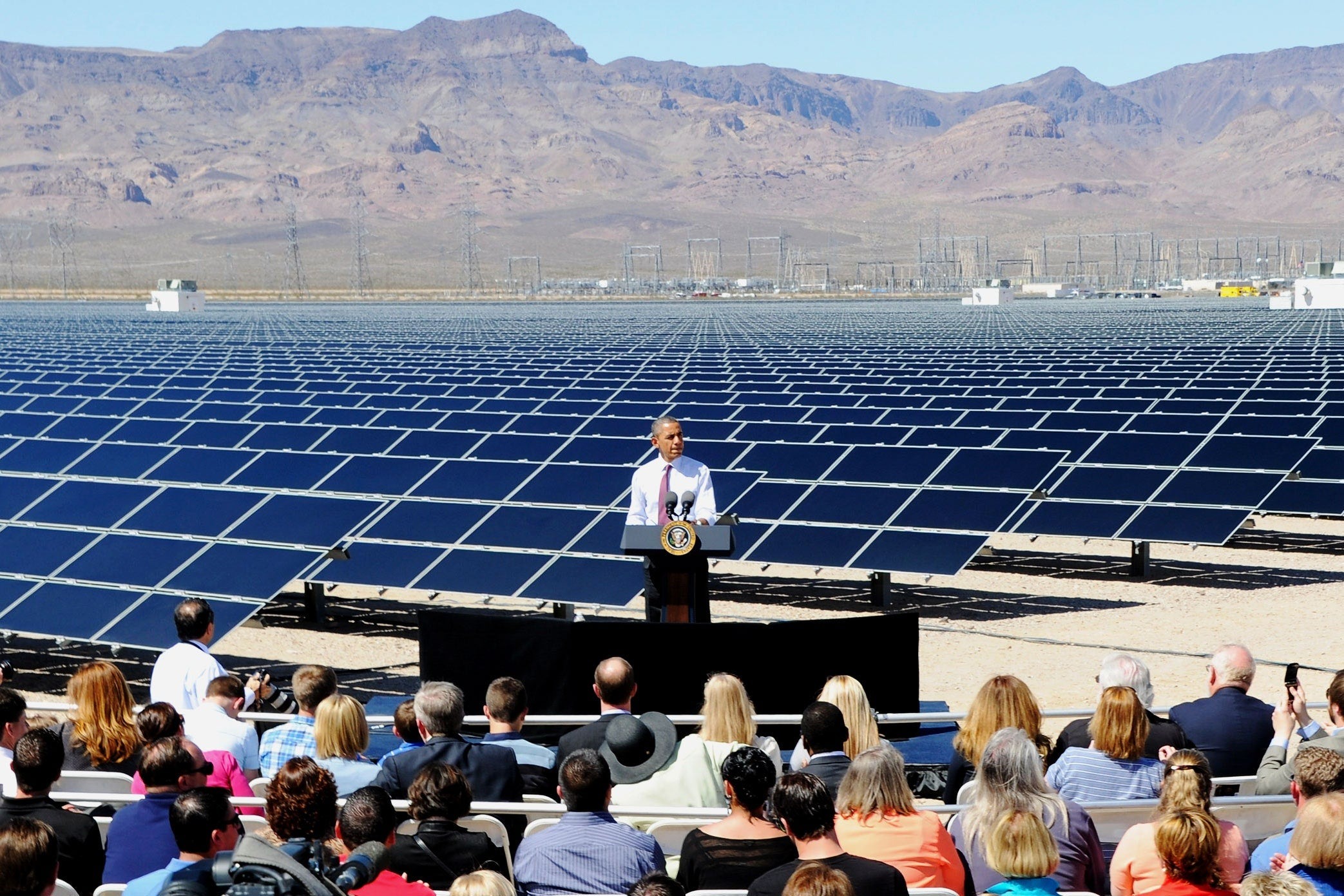 President Obama standing in front of ground mounted solar panels