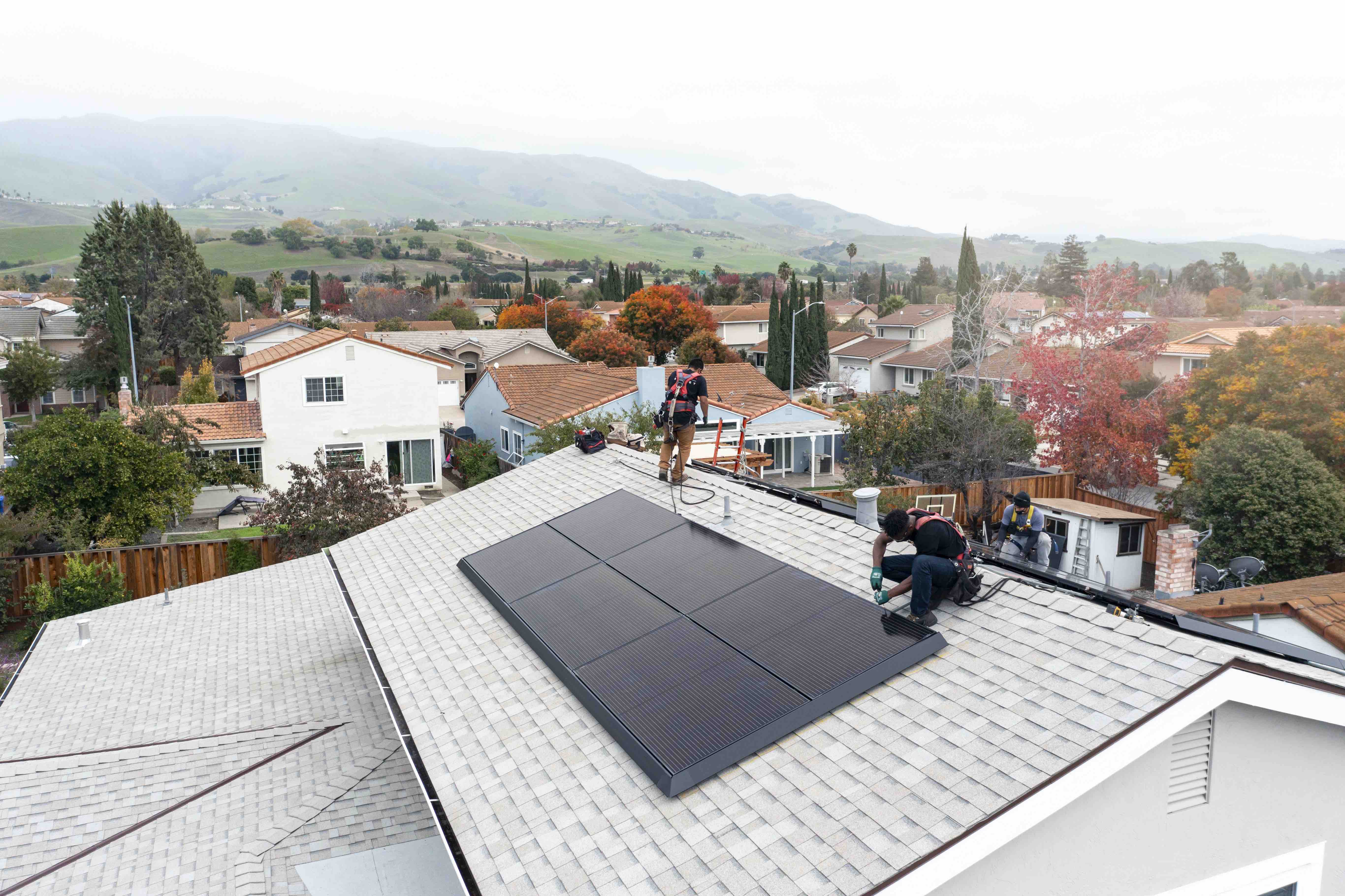 A 2-person Tesla crew on a roof finishing the solar installation