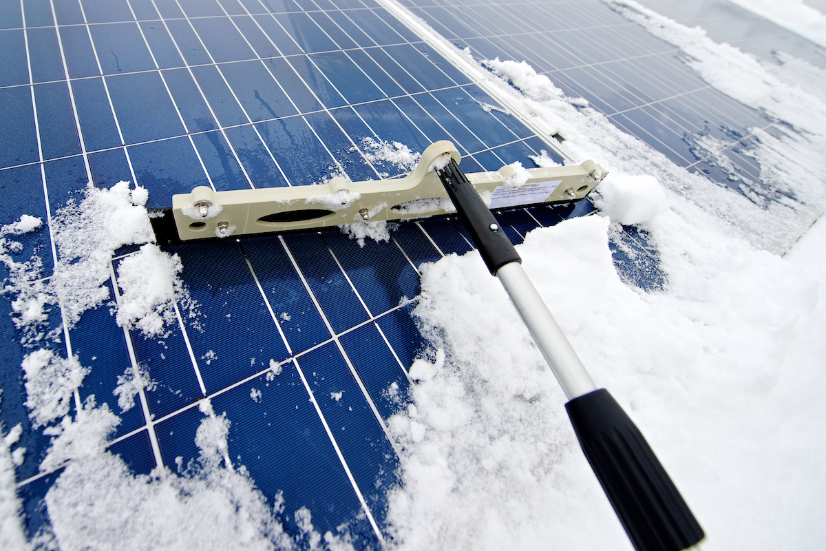 squeegee brushing snow off solar panels