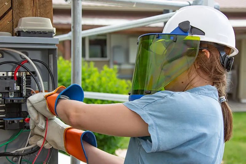 woman working on solar panels with safety glasses on